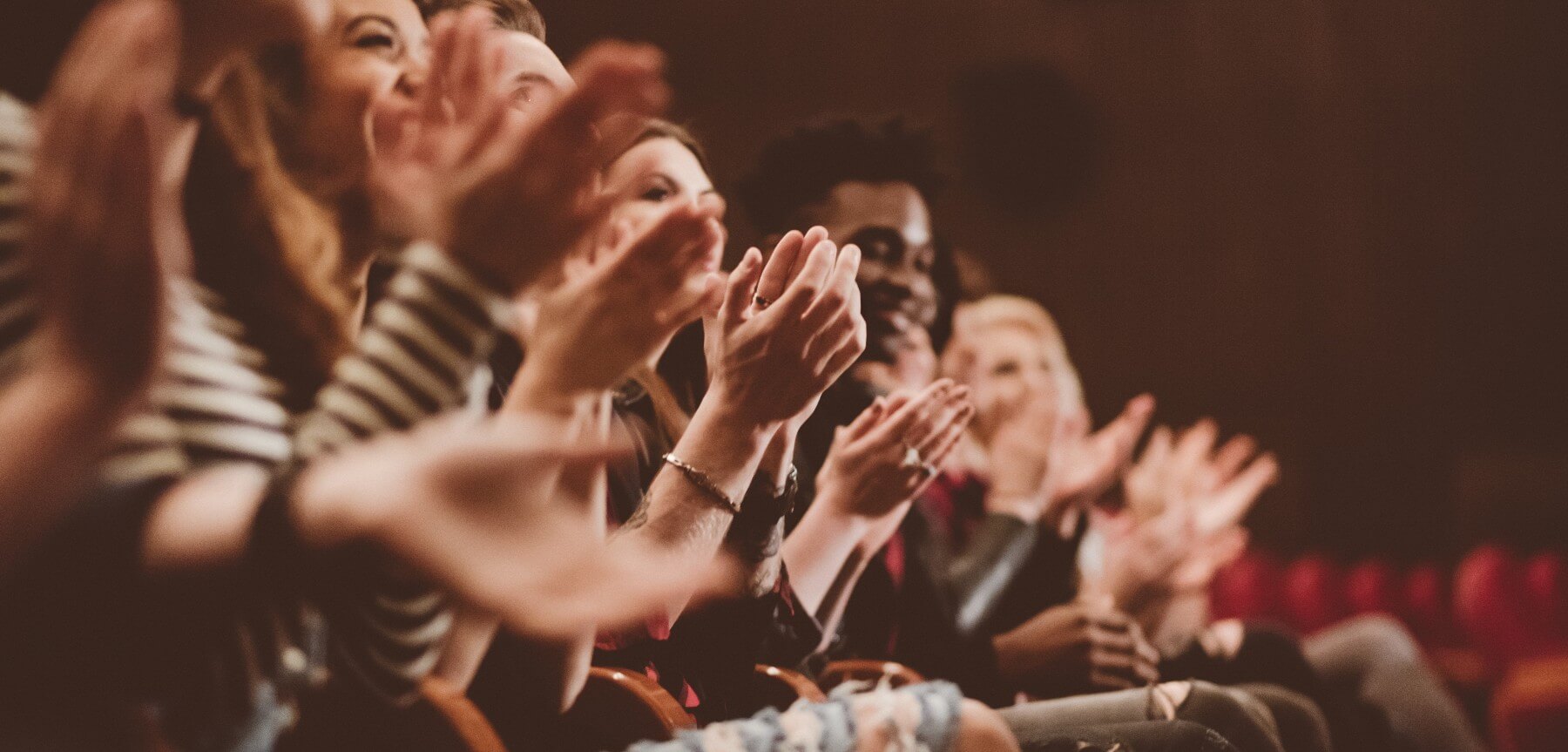 An audience watches a performance take place on the Jay Pritzker Pavilion, in front of the Chicago skyline.