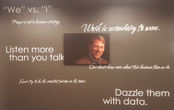 A memorial wall with a framed photograph of Rick Lester, surrounded by quotations.